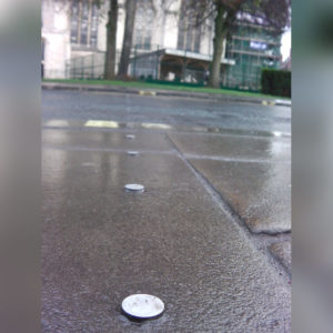 Standard stainless steel demarcation studs inserted in pavement